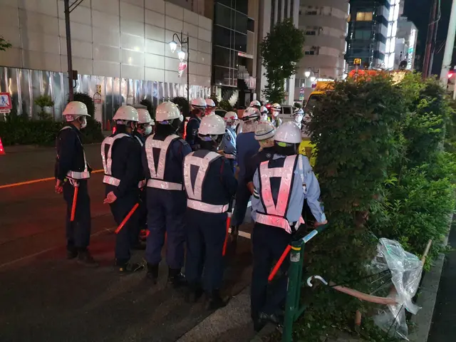 The image shows a group of police officers standing on the side of a road, wearing helmets and...