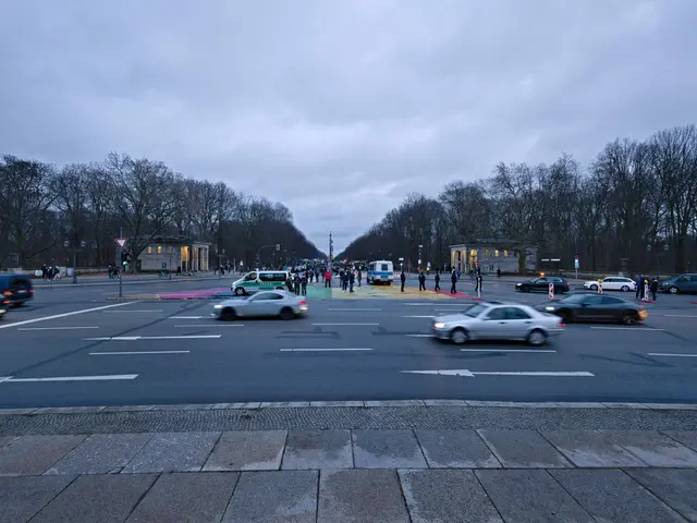 The image shows a city street filled with lots of traffic at dusk. There are vehicles on the road,...