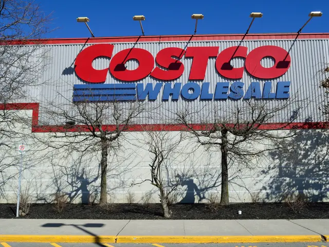 The image shows a Costco Wholesale store with a sign on the side of it, surrounded by trees,...
