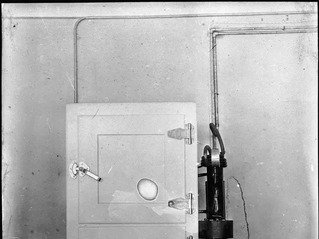 The image shows an old black and white photo of a door with a machine attached to it. The machine...