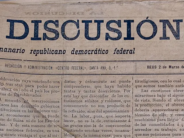 The image shows a newspaper with the word "discussion" written on it. The paper is yellowed with...