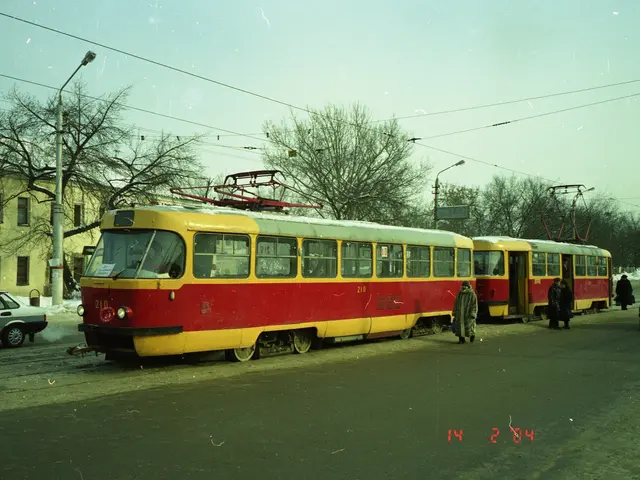 The image shows a red and yellow tram on a city street, surrounded by cars and people. In the...