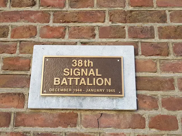 The image shows a brick wall with a plaque on it that reads "38th Signal Battalion". The plaque is...