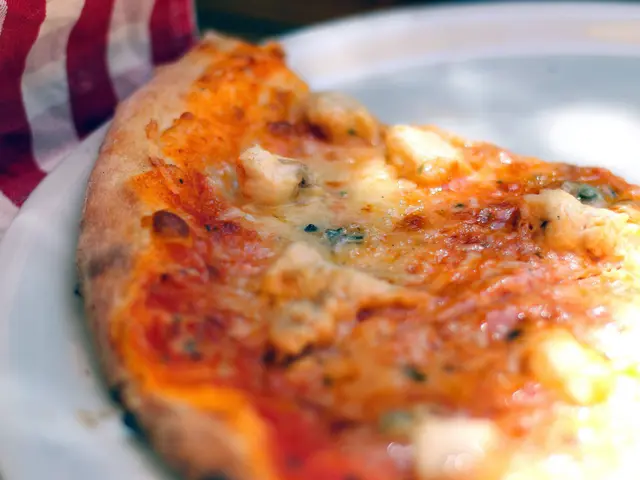 The image shows a close up of a Sicilian pizza on a white plate, placed on a table with a cloth...