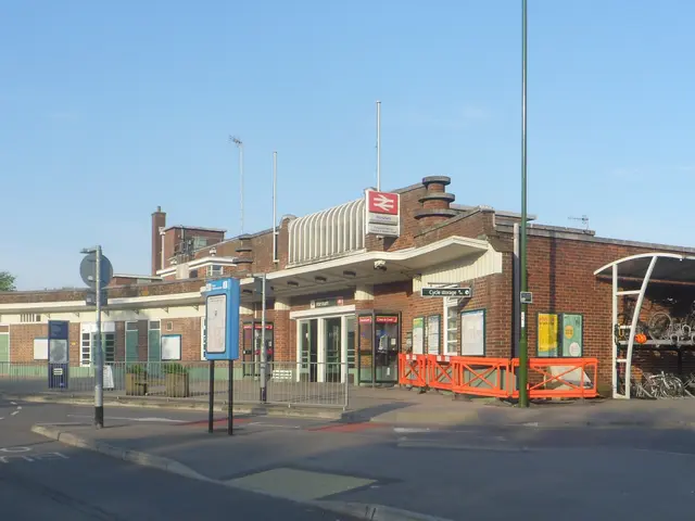 The image shows a train station with a lot of bicycles parked in front of it, surrounded by...