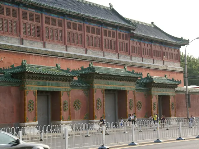 The image shows a car driving down a street next to a large building, which appears to be the...