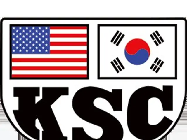The image shows the KSC logo, which consists of two flags, one of the United States and one of...