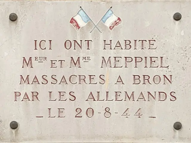 The image shows a plaque on the side of a building with two flags on it. The plaque is made of...