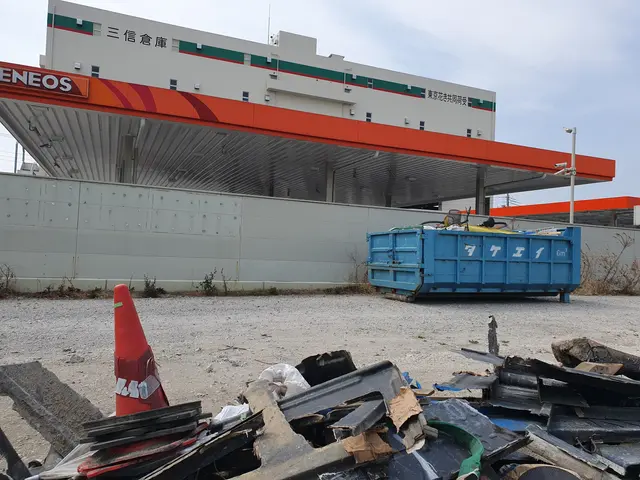 The image shows a large building with a lot of trash in front of it, including scrap metal, a...