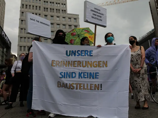 The image shows a group of people wearing masks and holding a banner that reads "Unsere...