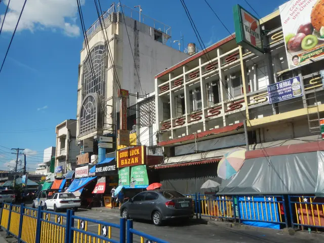 The image shows a bustling city street with cars driving down it, surrounded by tall buildings with...