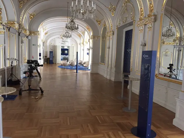 The image shows a large room with a wooden floor, white walls adorned with intricate designs, and a...
