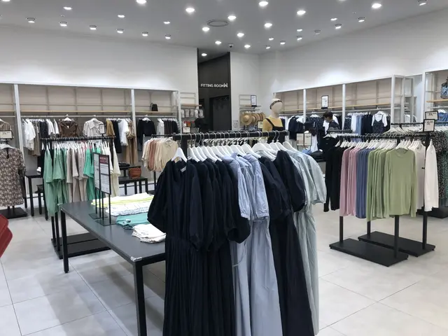 The image shows the inside of a clothing store with clothes on display. There are mannequins...