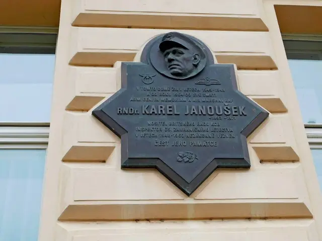 The image shows a plaque on the side of a building with a picture of a man in a hat, surrounded by...