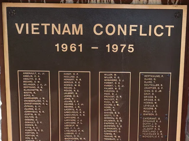 The image shows a plaque on the side of a brick building that reads "Vietnam Conflict 1961-1975"....