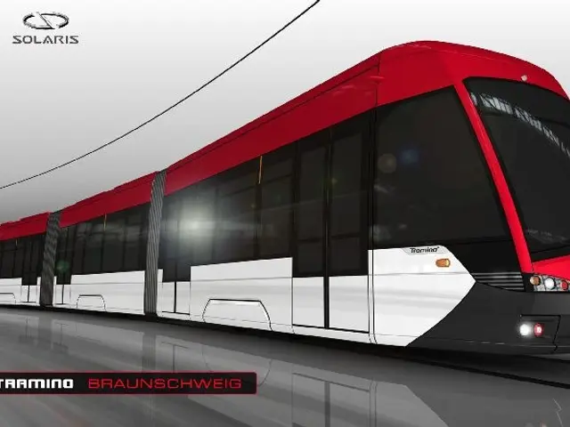 The image shows a red and white tram on a track, with electric poles and wires in the background....