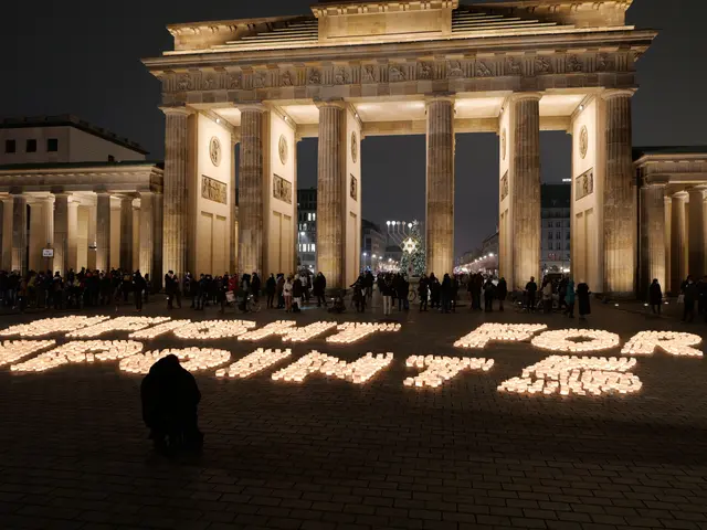 The image shows a group of people standing in front of the Brandenburg Gate in Berlin, Germany,...