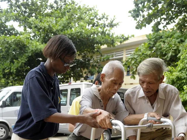 The image shows an elderly man with a walker being assisted by a nurse. In the background, there...