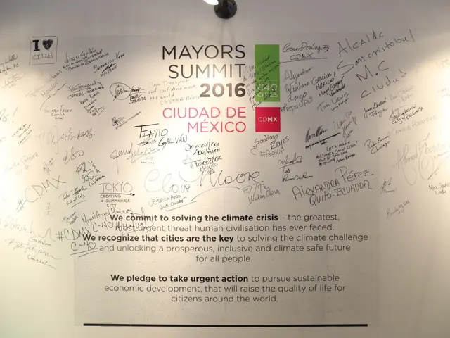 The image shows a white wall with a sign that reads "MAYORS SUMMIT 2016" written on it, illuminated...