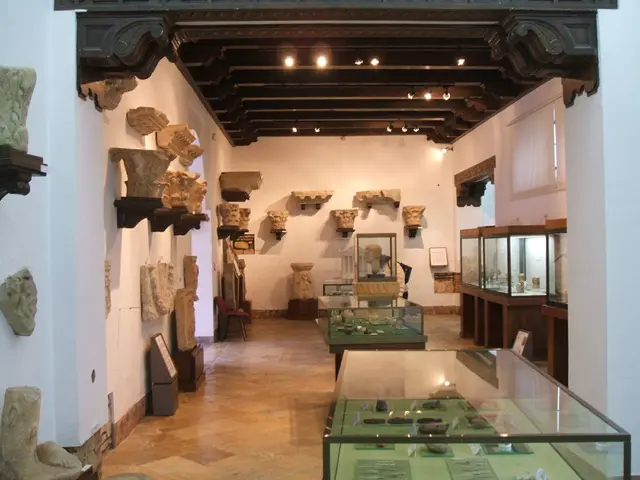 The image shows a room filled with lots of glass cases filled with artifacts, sculptures on the...