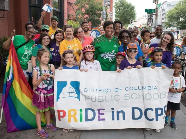 The image shows a group of people standing on the ground, some of them holding a banner that reads...