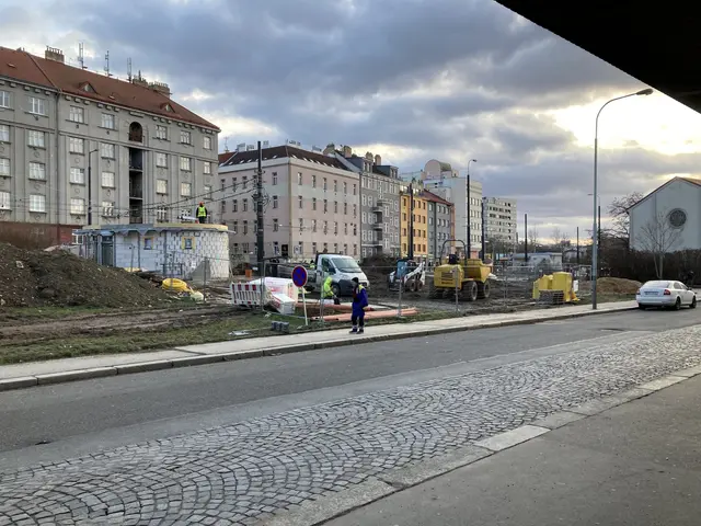 The image shows a city street with cars parked on the side of it. There are buildings with windows...