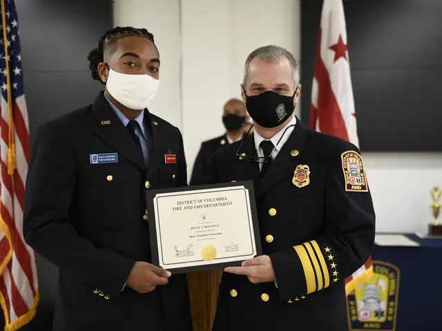 The image shows two men in uniform standing next to each other, both wearing masks and holding a...