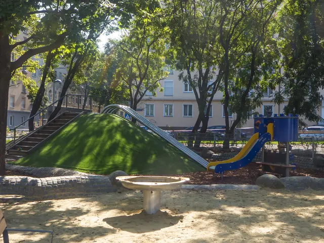The image shows a playground with a slide and a bench in the middle of it, surrounded by trees,...