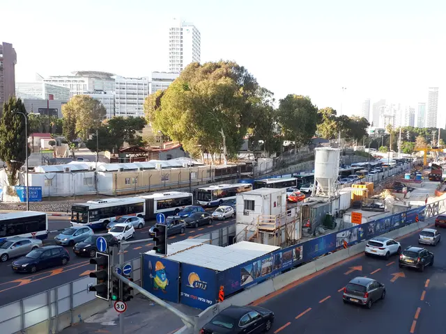 The image shows a busy city street filled with lots of traffic, including cars, buses, and trucks....
