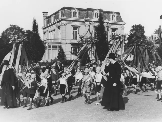 The image shows a group of people walking down a street in front of a building, with some of them...