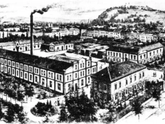 The image shows a black and white drawing of a city with buildings, trees, poles, and a hill in the...