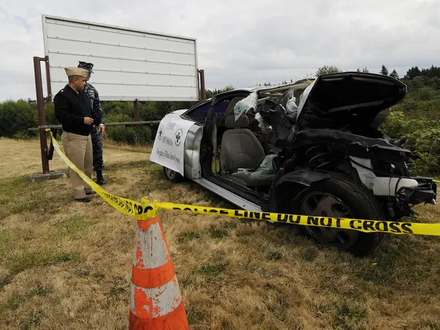 The image shows a police officer standing next to a car that has been involved in a crash on the...