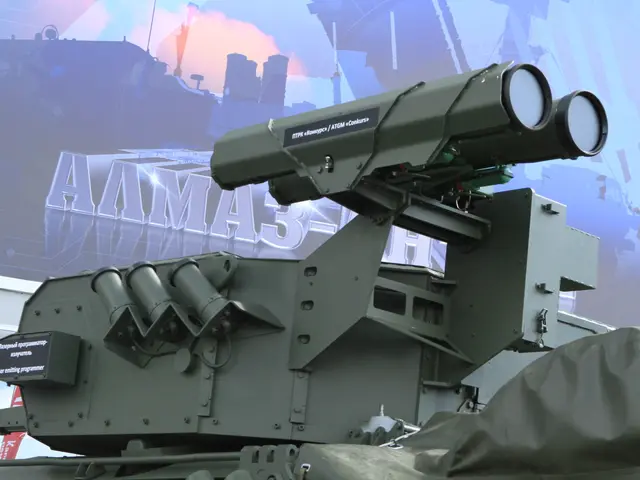 The image shows a military vehicle with a missile on top of it, parked in front of a building with...