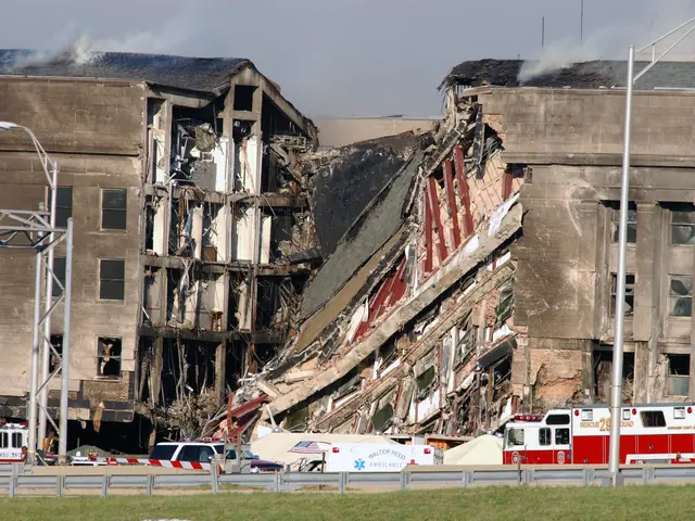The image shows a large building that has been partially demolished, with fire trucks parked in...