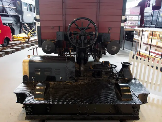 The image shows an old steam locomotive on display in a museum, surrounded by other trains on the...