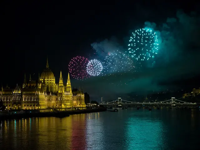 The image shows the Hungarian Parliament Building in Budapest illuminated by lights, with a bridge...