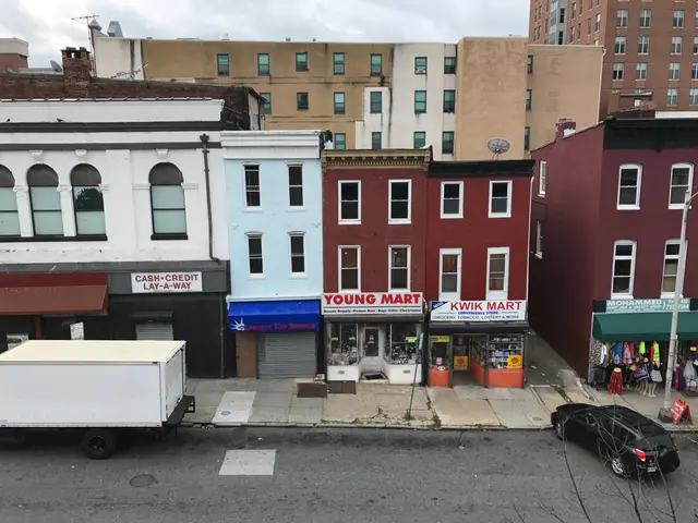 The image shows a view of a city street from the top of a building, with vehicles on the road,...