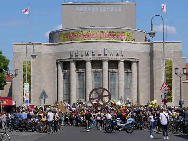 The image shows a large group of people standing in front of a building with pillars and text on...