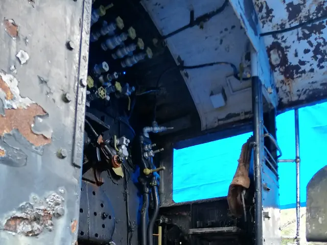 The image shows the inside of a truck with a lot of rust on it, and in the background there are...