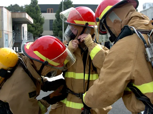 The image shows a group of three firefighters wearing firefighting gear, including helmets and...