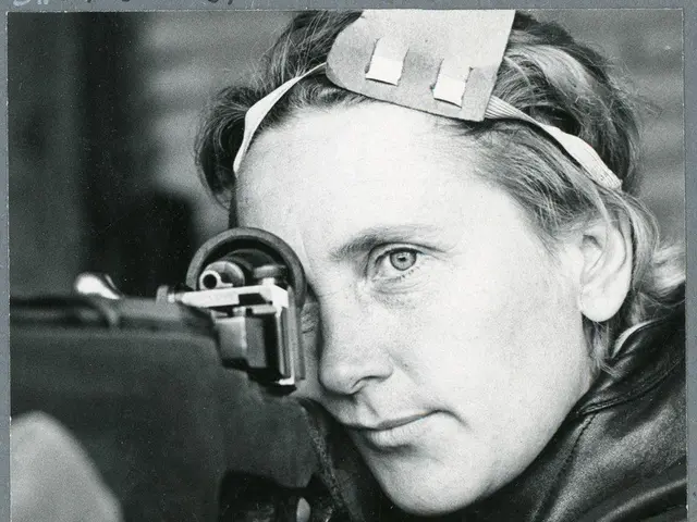 The image shows a black and white photo of a woman with a gun in her hand. She has a determined...
