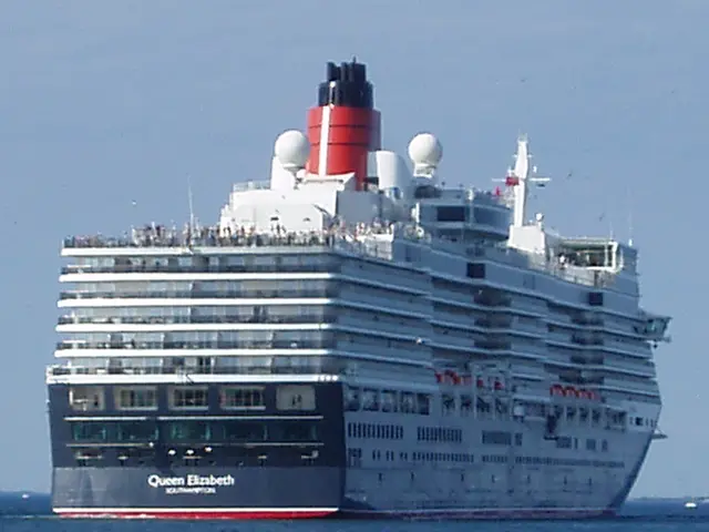 The image shows a large cruise ship, the Queen Elizabeth, sailing in the ocean with a few other...