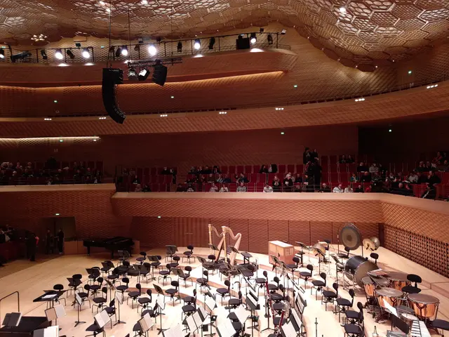 The image shows a large auditorium filled with lots of musical instruments, including chairs,...