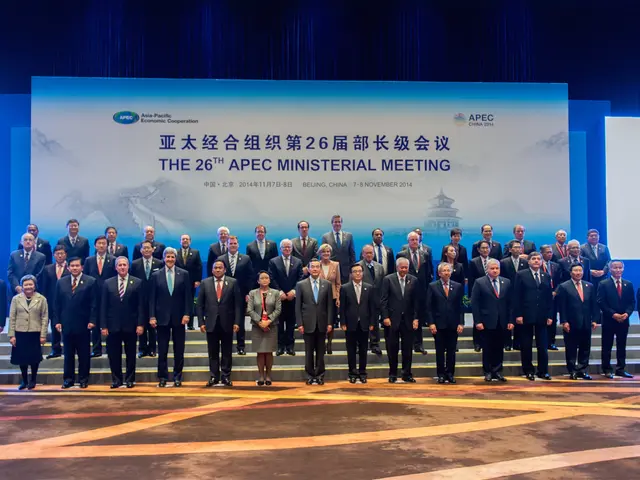 The image shows a group of people standing on top of a stage, wearing blazers, ties, shirts, and...