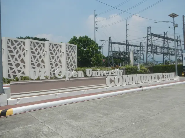 The image shows the entrance to Open University Community Hub, with a wall featuring text on it, a...