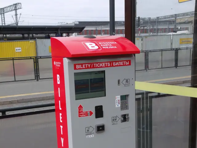 The image shows a red and white ticket vending machine sitting on the side of a street, with a...