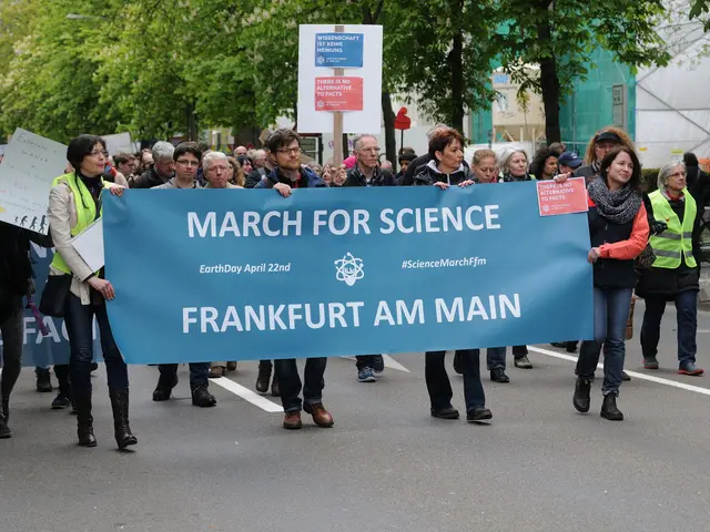 The image shows a group of people walking down a street, holding a banner that reads "March for...