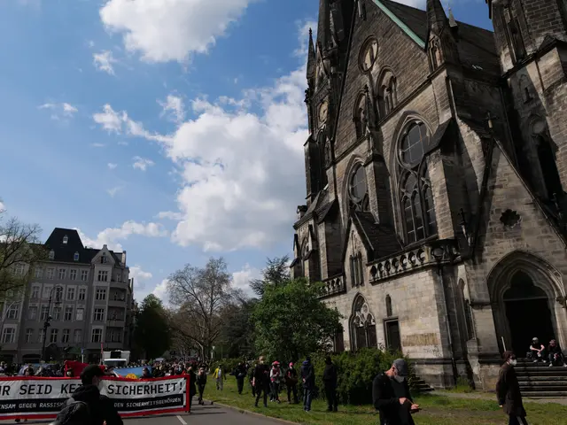 The image shows a group of people walking down a street in front of a church, with some of them...