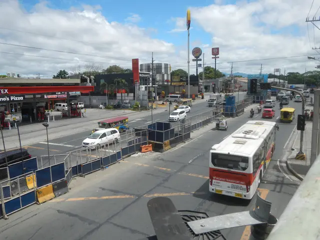 The image shows a city street filled with lots of traffic next to a gas station. We can see...