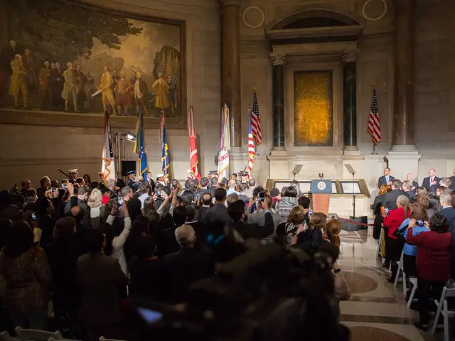 The image shows a large group of people standing in front of a crowd of people, some of whom are...